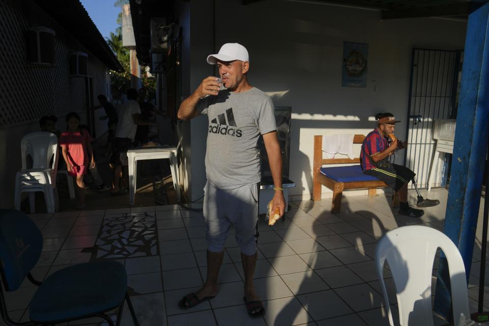 Cuban migrant Miguel Hidalgo drinks a glass of milk during breakfast at a shelter Rio Branco, Brazil, Saturday, June 22, 2024. Hidalgo who tried to cross to the U.S. years ago says, “I like Brazil. I have been here for a short time, but people are not prejudiced against me, people are lovely,” he said. (AP Photo/Martin Mejia)