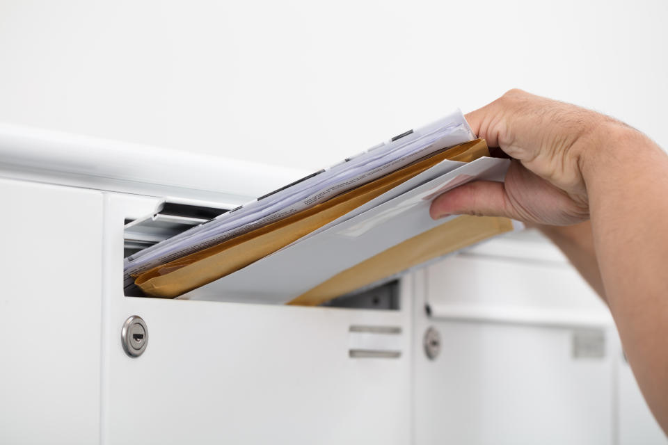 Close-up of a man's hand inserting letters in mailbox