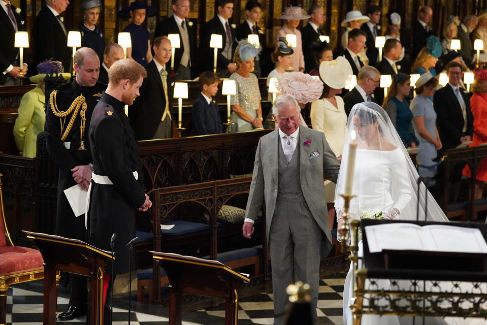 <p>Prince Harry, Duke of Sussex, looks at his bride, Meghan Markle, as she arrives at the altar accompanied by his father, Prince Charles. (Photo: Jonathan Brady/AFP/Getty Images) </p>