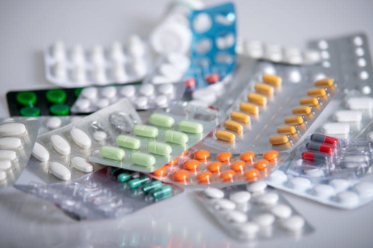 Various packets of coloured tablets on a table