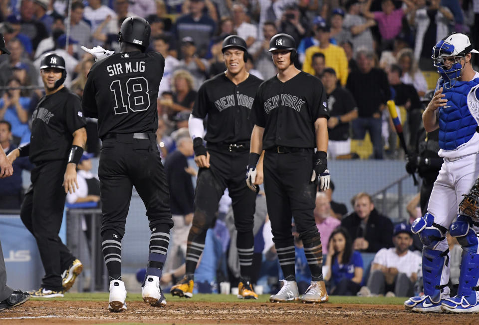 New York Yankees' Didi Gregorius, second from left, scores after hitting a grand slam as Gary Sanchez, left, Aaron Judge, center, and DJ LeMahieu wait for him as Los Angeles Dodgers catcher Will Smith stands nearby during the fifth inning of a baseball game Friday, Aug. 23, 2019, in Los Angeles. (AP Photo/Mark J. Terrill)