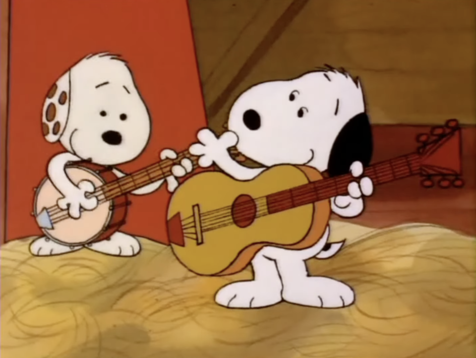A screenshot of the Snoopy cartoon playing a guitar with another puppy, who is playing a banjo.