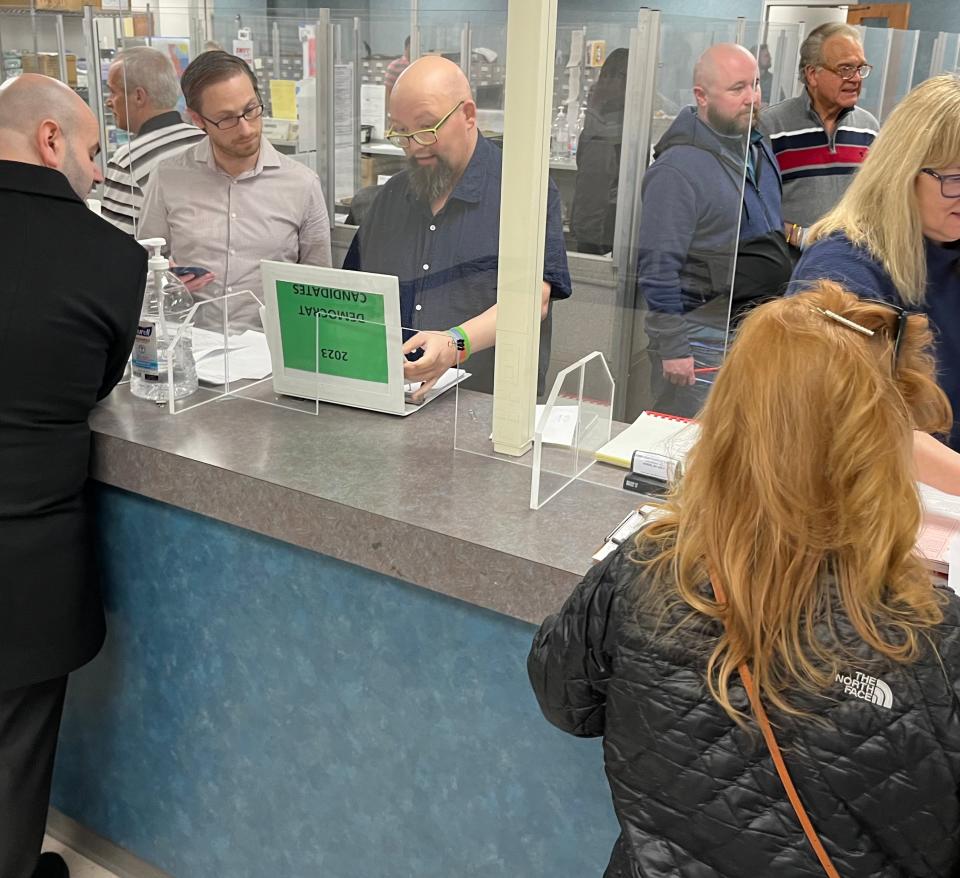 Summit County Board of Elections Director Lance Reed (left) and Deputy Director Pete Zeigler (right) review names in a book of candidates who filed to run in the May 2 primary.