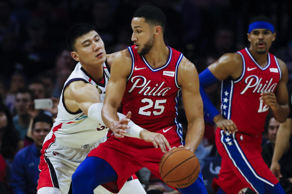 Philadelphia 76ers' Ben Simmons (25) drives to the net as Guangzhou Loong-Lions' Yongpeng Zhang defends and Philadelphia 76ers' Tobias Harris, right, watches during the first half of an NBA exhibition basketball game Tuesday, Oct. 8, 2019, in Philadelphia. (AP Photo/Matt Rourke)