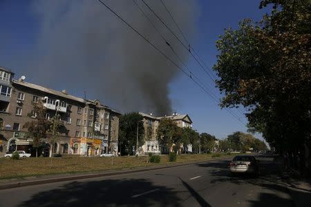 Smoke rises above a damaged building following what locals say was shelling by Ukrainian forces in Donetsk, eastern Ukraine August 27, 2014. REUTERS/Maxim Shemetov