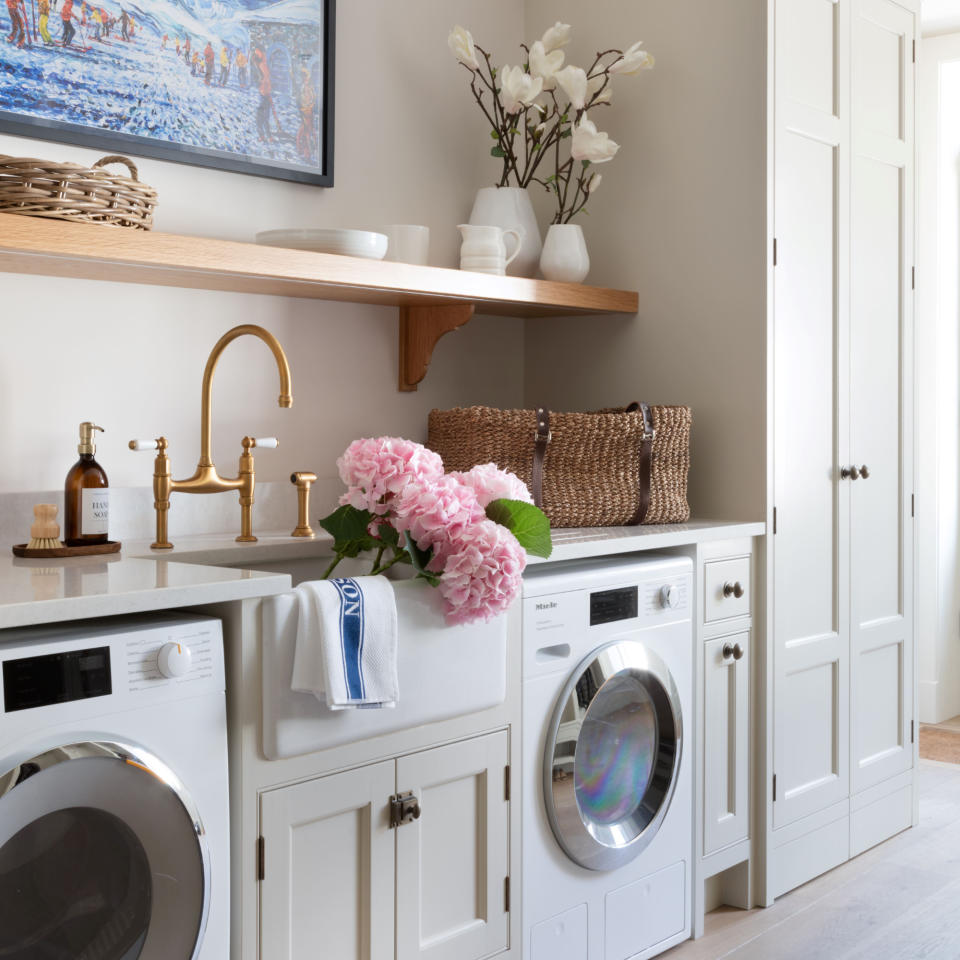  White kitchen with wood accents and fitted washing machine. 