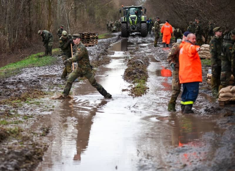 German Armed Forces (Bundeswehr) soldiers secure a dyke on the Helme with sandbags in the flood areas in Saxony-Anhalt Jan Woitas/dpa