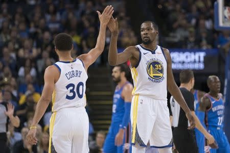 October 16, 2018; Oakland, CA, USA; Golden State Warriors forward Kevin Durant (35) high-fives guard Stephen Curry (30) against the Oklahoma City Thunder during the third quarter at Oracle Arena. Mandatory Credit: Kyle Terada-USA TODAY Sports