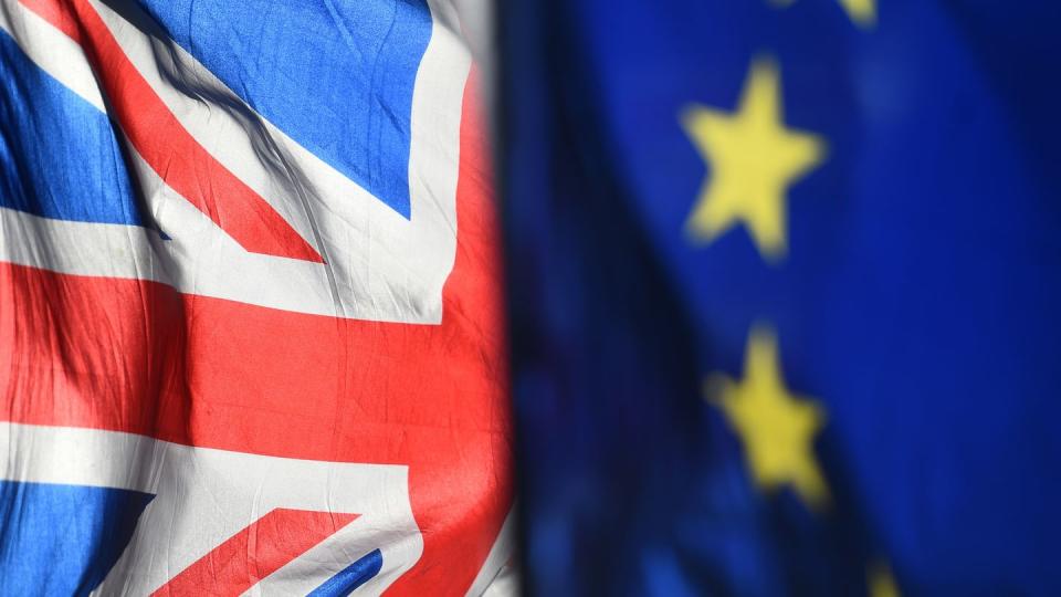 Eine Flagge der Europäischen Union und eine Flagge von Großbritannien wehen vor dem Parlament in Westminster.