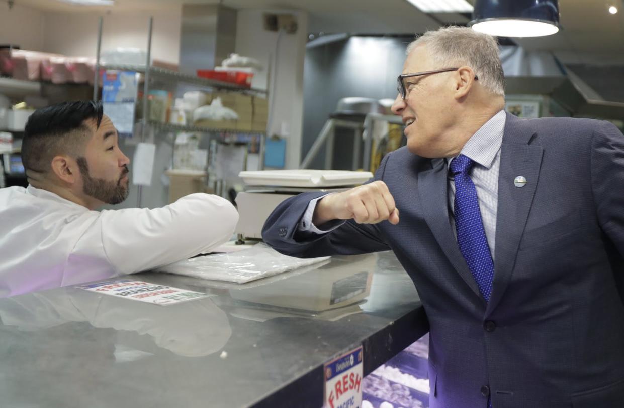 <span class="caption">Washington Gov. Jay Inslee, right, bumps elbows with a worker at the seafood counter March 3, 2020, in Seattle's International District.</span> <span class="attribution"><a class="link " href="http://www.apimages.com/metadata/Index/APTOPIX-Virus-Outbreak-Washington/71004379cdf54685b00708552cd57d72/2/0" rel="nofollow noopener" target="_blank" data-ylk="slk:AP Photo/Ted S. Warren;elm:context_link;itc:0;sec:content-canvas">AP Photo/Ted S. Warren</a></span>
