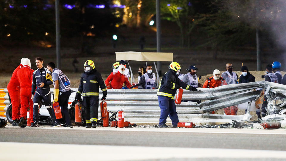 Officials, pictured here clearing debris from the track after Romain Grosjean's scary crash. 