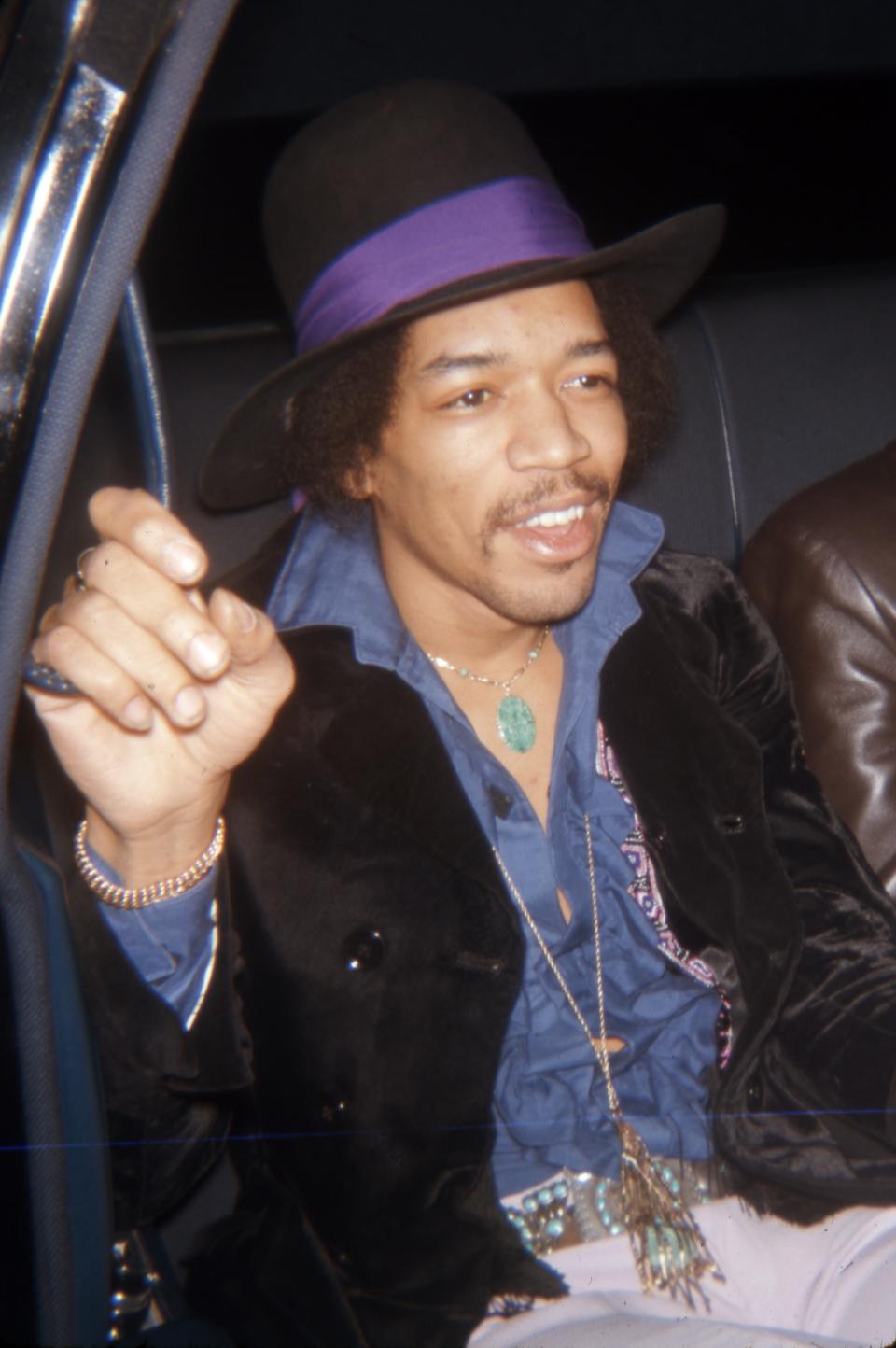 A photo of Jimi Hendrix in the back of a car.