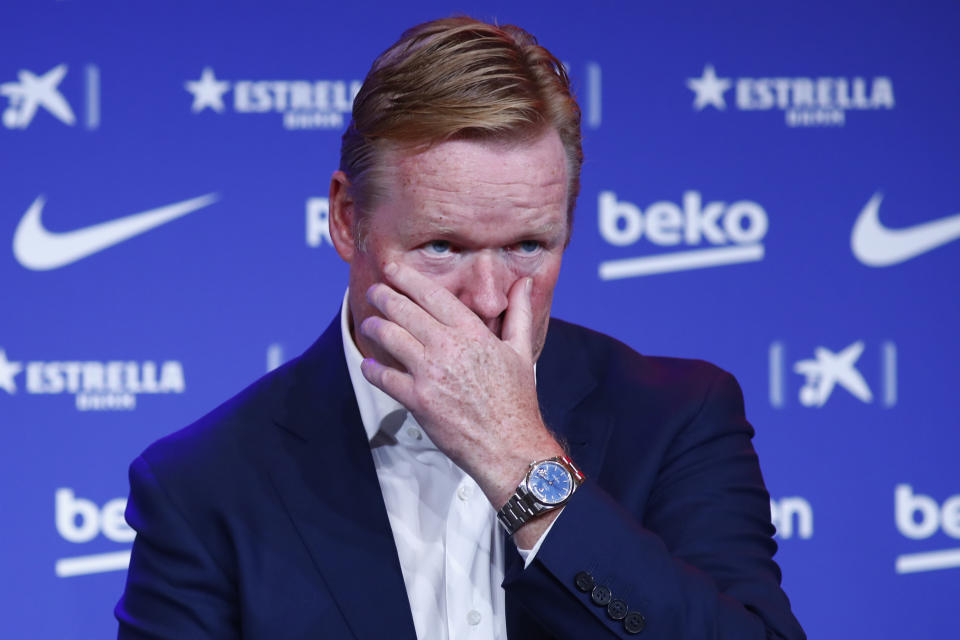 Ronald Koeman touches his face during his official presentation as coach for FC Barcelona in Barcelona, Spain, Wednesday, Aug. 19, 2020. Barcelona officially announced earlier on Wednesday a deal with Koeman to become their coach five days after the team's humiliating 8-2 loss to Bayern Munich in the Champions League quarterfinals. Barcelona says the former defender's deal runs through June 2022. Koeman replaces the fired Quique Setien. (AP Photo/Joan Monfort)