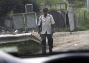 In this Oct. 3, 2019 photo, a vigilante walks down from a sniper post where he guards against thieves and drug cartel extortionists, on the outskirts of Tepalcatepec, in Mexico's state of Michoacan, the heartland of world production of the fruit locals call "green gold." (AP Photo/Marco Ugarte)