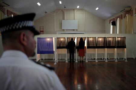Gibraltar's Chief Minister Fabian Picardo (L) and his wife Justine Olivero prepare their ballots inside a polling booth before casting their votes for the EU referendum at a polling station in the British overseas territory of Gibraltar, historically claimed by Spain, June 23, 2016. REUTERS/Jon Nazca