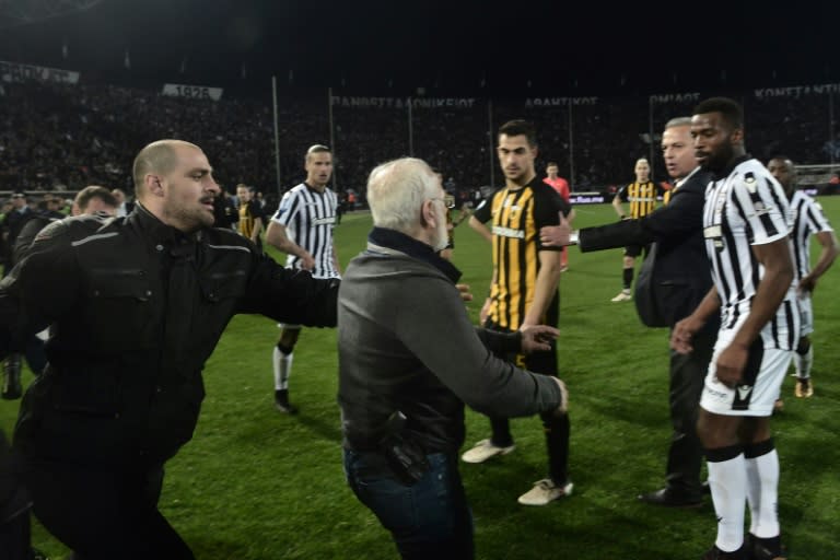 The Greek government suspended the football league after PAOK FC owner Ivan Savvidis (C) took to the pitch carrying a handgun in his waistband (below C)