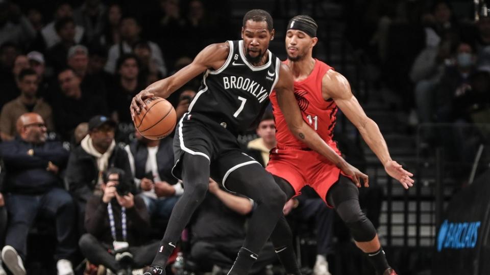 Brooklyn Nets forward Kevin Durant looks to spin away from Portland Trail Blazers guard Josh Hart.