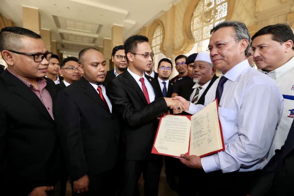 Johor Opposition leader Datuk Hasni Mohammad (right) hands over the memorandum to the Johor MB’s private secretary Muhd Shamsuddin Paijan at the state administrative office in Iskandar Puteri. — Picture by Ben Tan