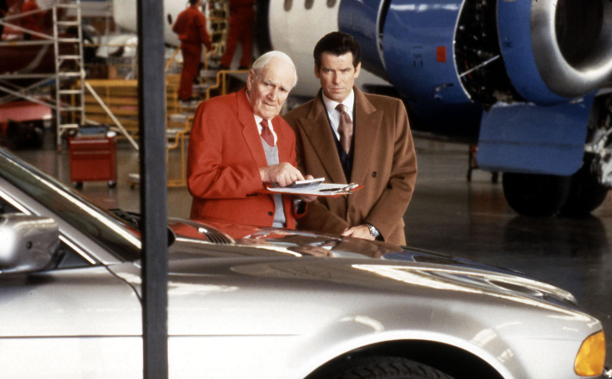 Desmond Llewelyn and Pierce Brosnan on the set of Tomorrow Never Dies. (Alamy)