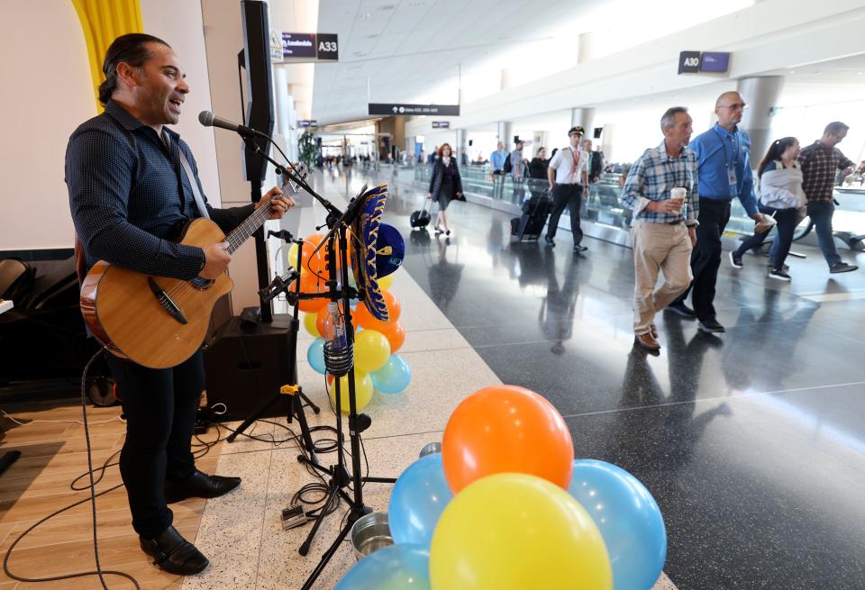 Jean Pierre De Rurange plays guitar and sings at Blue Iguana as travelers pass through Salt Lake City International Airport in Salt Lake City on Tuesday, Oct. 31, 2023. 13 new gates in Concourse A are now open, along with new concessions such as Blue Iguana. | Kristin Murphy, Deseret News