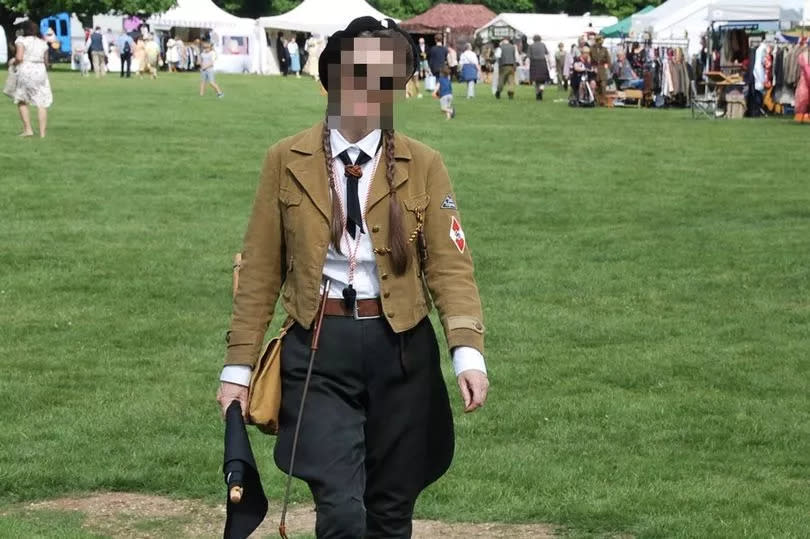 A woman wearing what appears to be a Hitler Youth uniform