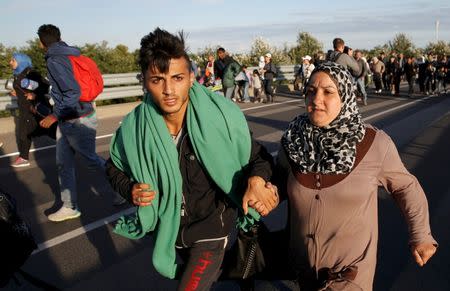 Migrants run against the traffic on a motorway leading to Budapest as they escape a transit camp in the village of Roszke, Hungary, September 7, 2015. REUTERS/Marko Djurica