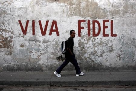 A man walks past a graffitti that reads "Long live Fidel" in Santiago de Cuba in this December 29, 2008 file photo. REUTERS/Claudia Daut/File Photo