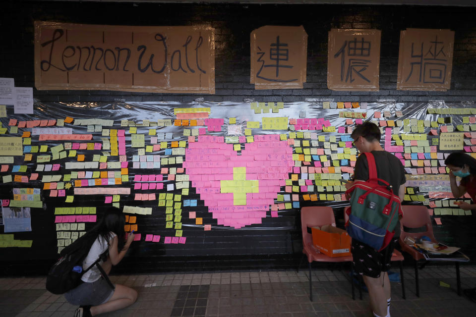 Supporters of protests visit a Lennon Wall where colorful labels with messages demanding the Hong Kong government retract a controversial extradition bill are attached, in Hong Kong Friday, Aug. 2, 2019. Protesters plan to return to the streets again this weekend, angered by the government's refusal to answer their demands, violent tactics used by police — possibly in coordination with organized crime figures. (AP Photo/Vincent Thian)