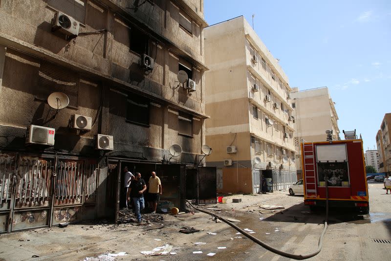 Firefighters put out a fire inside a shop after yesterday's clashes in Tripoli