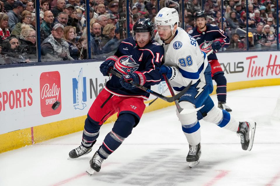 Oct 14, 2022; Columbus, Ohio, USA;  Columbus Blue Jackets left wing Gustav Nyquist (14) fights for a puck with Tampa Bay Lightning defenseman Mikhail Sergachev (98) during the third period of the NHL hockey game at Nationwide Arena. The Blue Jackets lost 5-2. Mandatory Credit: Adam Cairns-The Columbus Dispatch