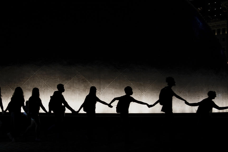 Protesters wear mask and link their hands forming a human chain during a protest in Hong Kong, Friday, Oct. 18, 2019. Hong Kong pro-democracy protesters are donning cartoon/superheroes masks as they formed a human chain across the semiautonomous Chinese city, in defiance of a government ban on face coverings. (AP Photo/Felipe Dana)