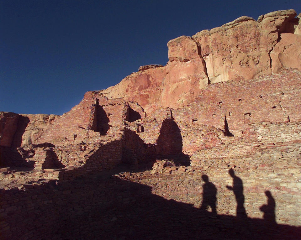 FILE - In this Nov. 21, 1996, file photo, tourists cast their shadows on the ancient Anasazi ruins of Chaco Culture National Historical Park in New Mexico. The checkerboard of federal land surrounding Chaco Culture National Historical Park would be off limits to oil and gas development under legislation pending before Congress. The U.S. House is set to vote on the measure Wednesday, Oct. 30, 2019. (AP Photo/Eric Draper, File)