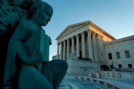 A figure of a child holding an open book decorates a flagpole at the U.S. Supreme Court building in Washington, U.S. on October 5, 2014. REUTERS/Jonathan Ernst/Files