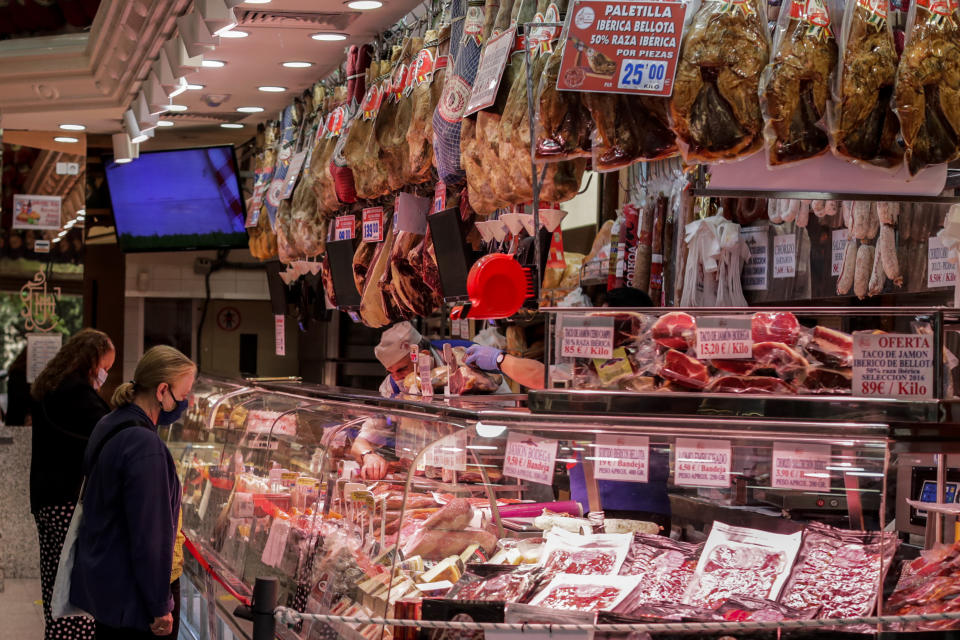 People wearing face masks to prevent the spread of coronavirus buy charcuterie products in downtown Madrid, Spain, Friday, Sept. 18, 2020. With more than 11,000 new daily coronavirus cases, the attention in Spain is focusing on its capital, where officials are mulling localized lockdowns and other measures to bring down the curve of contagion. (AP Photo/Manu Fernandez)