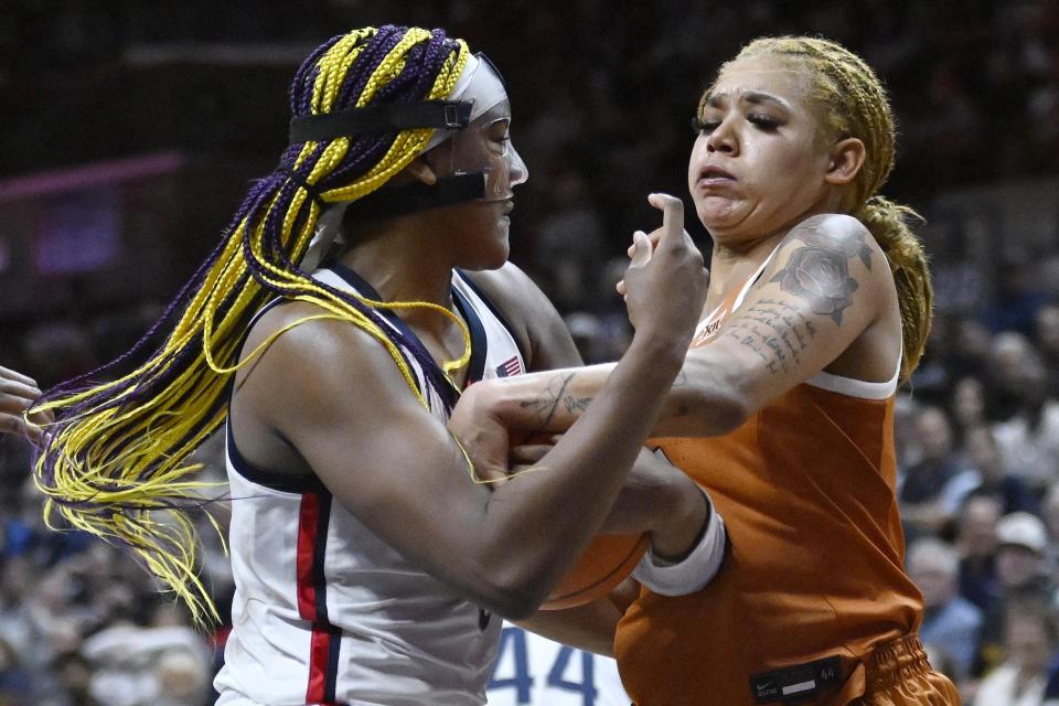 Connecticut's Aaliyah Edwards, left, and Texas' Sonya Morris, right, fight for the ball during the second half of an NCAA college basketball game, Monday, Nov. 14, 2022, in Storrs, Conn. (AP Photo/Jessica Hill)