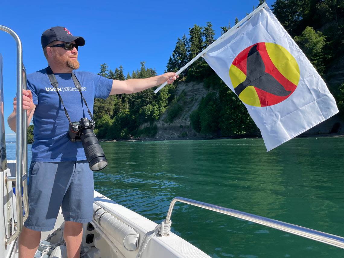 Ryan Dicks shows off his boat’s whale flag. The flags are part of an effort by the partnership Be Whale Wise to improve marine life education among sailors.