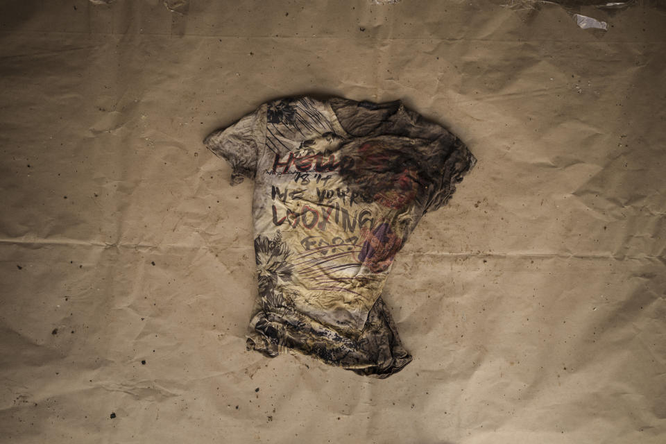 A printed T-shirt that reads "Hello, is it me you're looking for?" found on a deceased migrant whose remains were recovered from a Mauritania boat on May 28, 2021, is laid out at the Scarborough police station on the island of Tobago, Trinidad and Tobago, Friday, Jan. 21, 2022. (AP Photo/Felipe Dana)