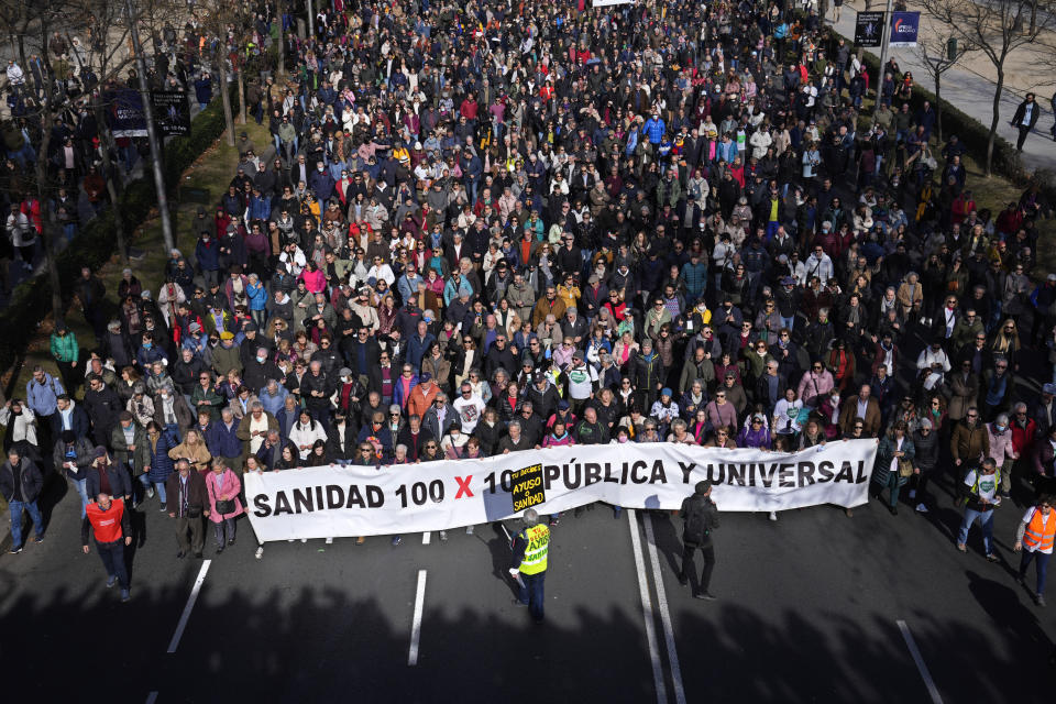 Protesters march to support the public heath service in one of four columns which will meet in the centre of Madrid, Spain, Sunday, Feb. 12, 2023. Several thousand health workers returned to the streets of Spain's capital Sunday to protest what they claim is the dismantling of Madrid's public health care system by its conservative regional government.(AP Photo/Paul White)