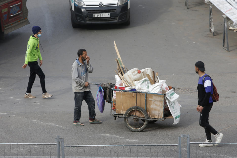 People walk through the streets in Casablanca, Morocco, Tuesday, April 6, 2021. Moroccan authorities have announced the discovery of a new local variant of the coronavirus and extended an overnight curfew as infections rise again. (AP Photo/Abdeljalil Bounhar)