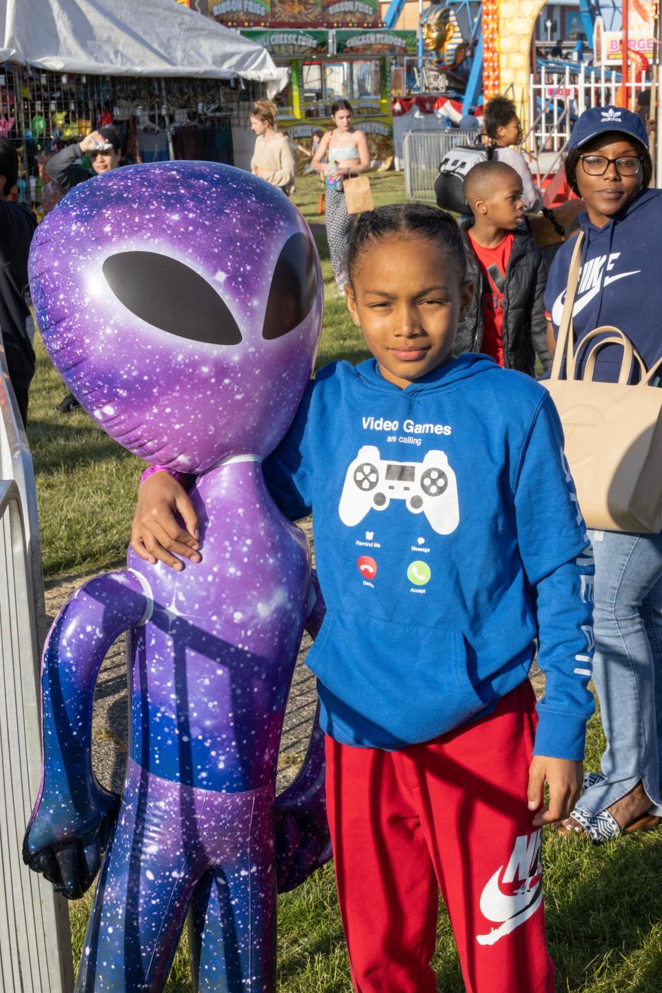 La'zavier White of Neptune takes care of a blow up Alien they won for their brother as he enjoys one of the rides at the Carnival in Asbury Park. Memorial Day weekend gets off to a good start in Asbury Park, NJ on May 26, 2023. 