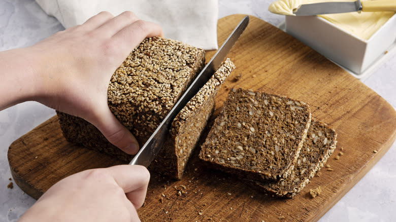 person slicing rye bread