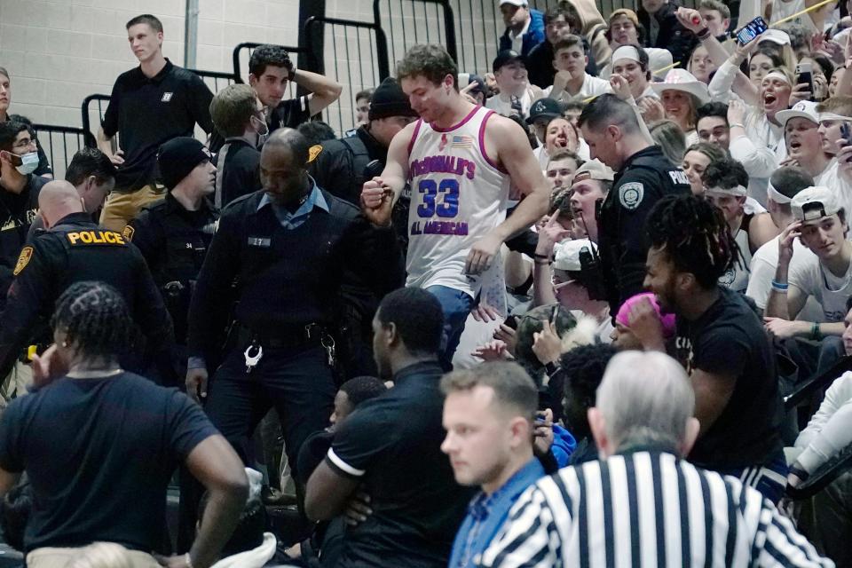 Police remove a fan from the stands after an altercation stopped play during the second half of the Northeast Conference championship game between Bryant and Wagner.