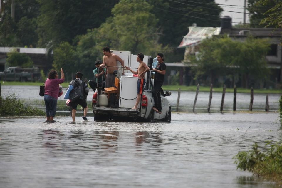 Habitantes de Ixtacomitan abandonan sus hogares debido a las inundaciones por las intensas lluvias.