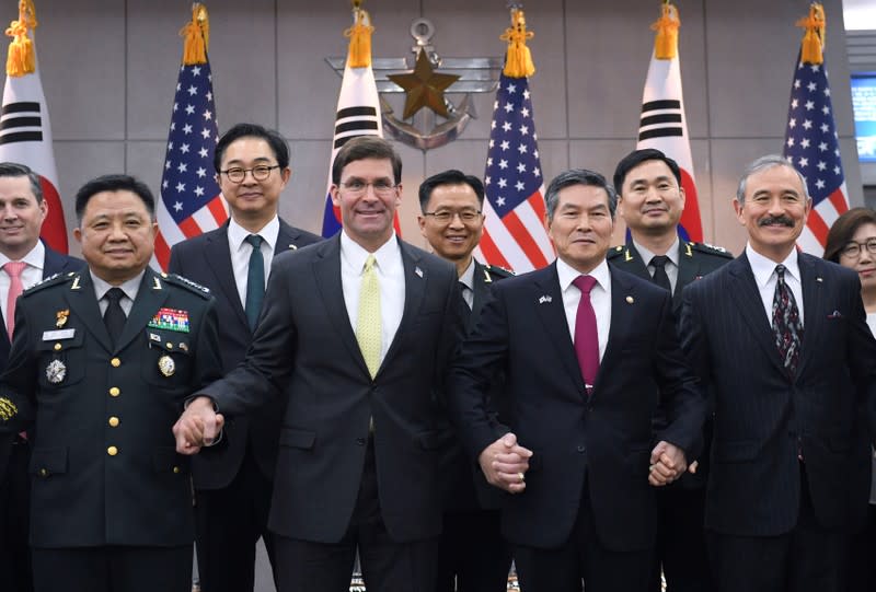 U.S. Defense Secretary Esper holds hands with South Korean Defense Minister Jeong before their meeting in Seoul