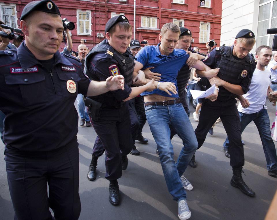 FILE - In this July 10, 2013, file photo, police officers detain Russian opposition leader Alexei Navalny, center, in Moscow, Russia. Navalny is an anti-corruption campaigner and the Kremlin’s fiercest critic. He has outlasted many opposition figures and is undeterred by incessant attempts to stop his work. (AP Photo/Evgeny Feldman, File)