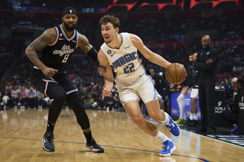 Orlando Magic forward Franz Wagner (22) drives to the basket against Los Angeles Clippers forward Marcus Morris Sr. (8) during the first half of an NBA basketball game Saturday, March 18, 2023, in Los Angeles. (AP Photo/Allison Dinner)