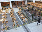 Lone man walks past chairs and tables in an empty food court in a shopping mall in Toronto, Ontario, Canada on March 21, 2020. Restaurants have been prohibited from allowing dine-in service and food courts and cafeterias have been ordered to be closed by the Province of Ontario, with any deciding to remain open facing steep fines and penalties. Retailers in malls across Canada have shuttered their stores due to the novel coronavirus (COVID-19) outbreak. Many malls are limiting entry to only 50 visitors at a time. (Photo by Creative Touch Imaging Ltd./NurPhoto via Getty Images)