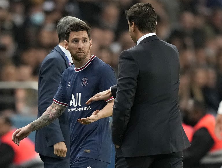 Lionel Messi observa al técnico el PSG Mauricio Pochettino tras ser sustituido en el partido contra Lyon por la liga de Francia