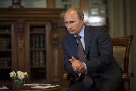 Russian President Vladimir Putin listens to French politician and businessman Philippe de Villiers during their meeting at the Livadia Palace outside Yalta, Crimea, August 14, 2014. REUTERS/Alexander Zemlianichenko/Pool