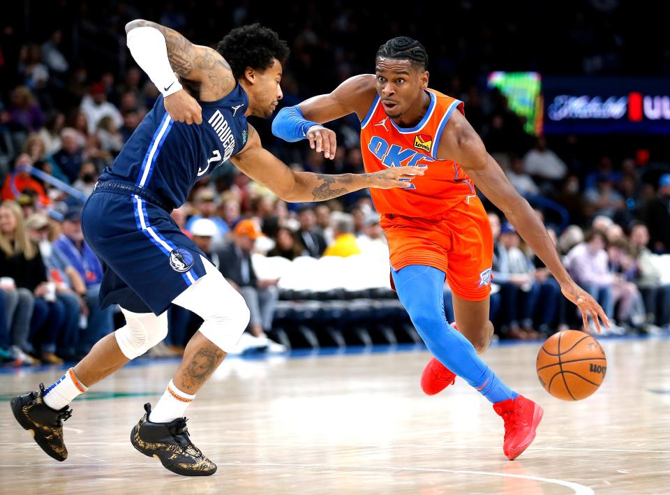 Oklahoma City's Shai Gilgeous-Alexander (2) works to get around Dallas' Trey Burke (3) during the NBA basketball game between the Oklahoma City Thunder and the Dallas Mavericks at the Paycom Center in Oklahoma City, Sunday, Dec. 12, 2021.